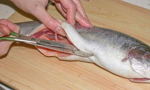Menghiris ikan dengan berhati-hati pada papan pemotong peribadi melindungi daripada serangan parasit